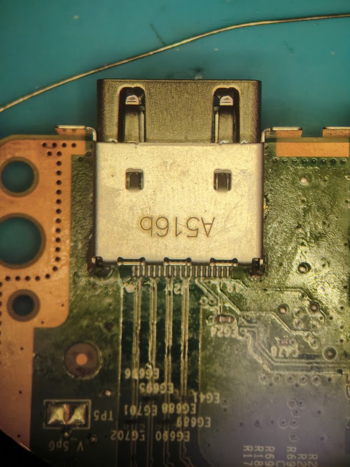 Close-up of an HDMI port soldered to a green circuit board